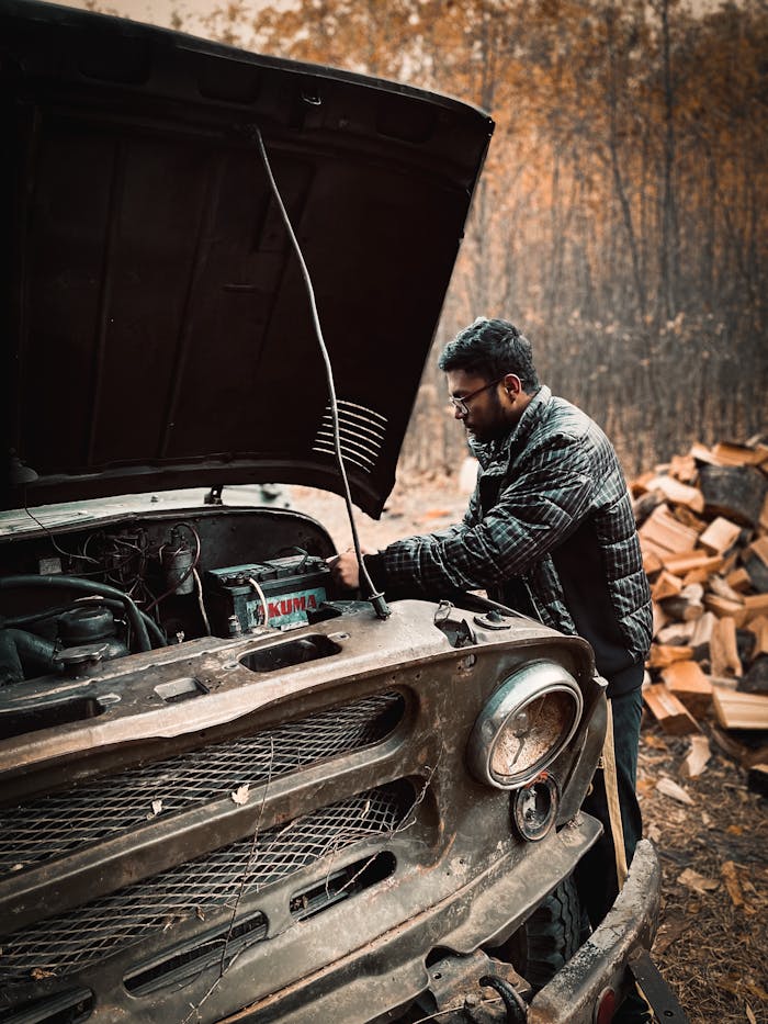 menu-08 A mechanic repairing a vintage vehicle's engine outdoors in Chișinău, Moldova.